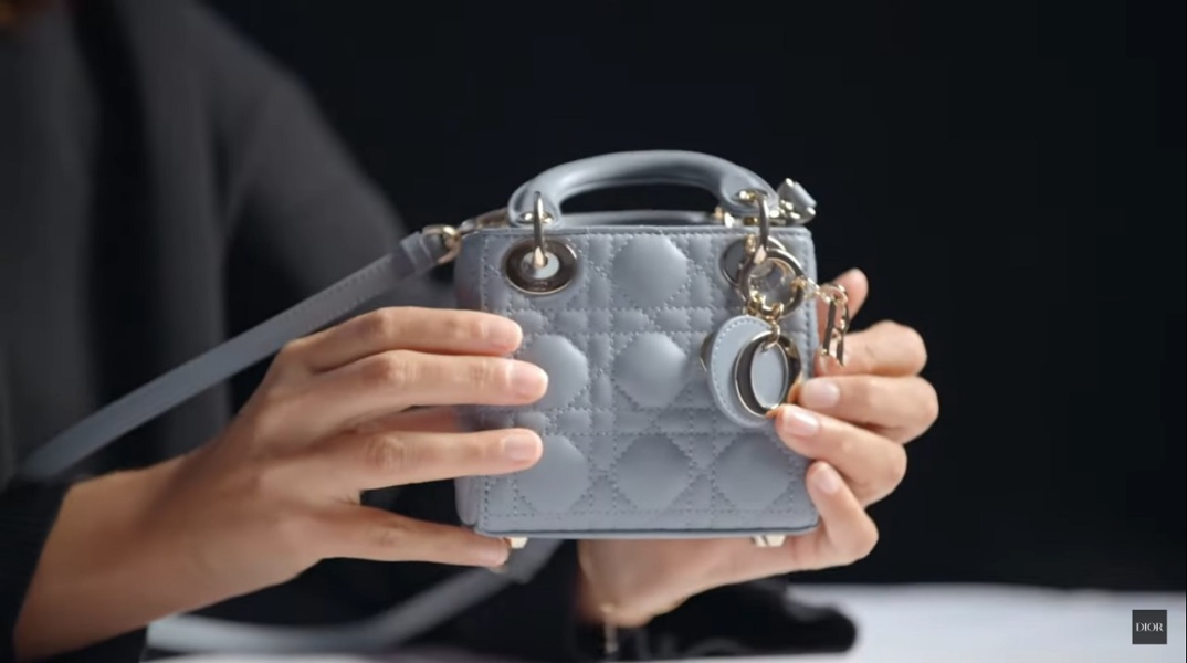 Γυναίκα κρατάει μινιατούρα τσάντα Dior
