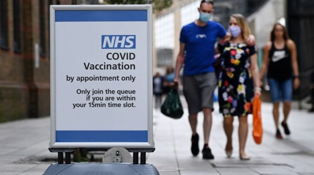 Κορωνοϊός: Πολίτες με μάσκα στη Βρετανία © EPA / ANDY RAIN 