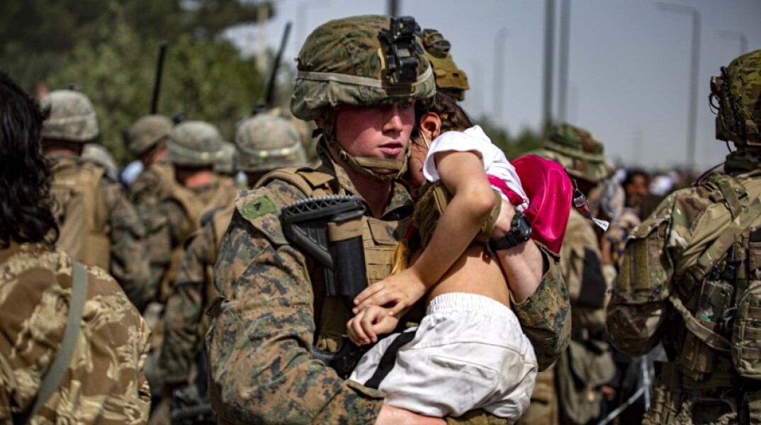 Αμερικανός στρατιώτης κρατάει ένα μωρό στην Αγκαλιά του στο αεροδρόμιο της Καμπούλ © EPA / U.S. Marine Corps photo by 1stLt