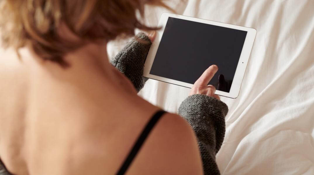 Γυναίκα κρατά κινητό τηλέφωνο