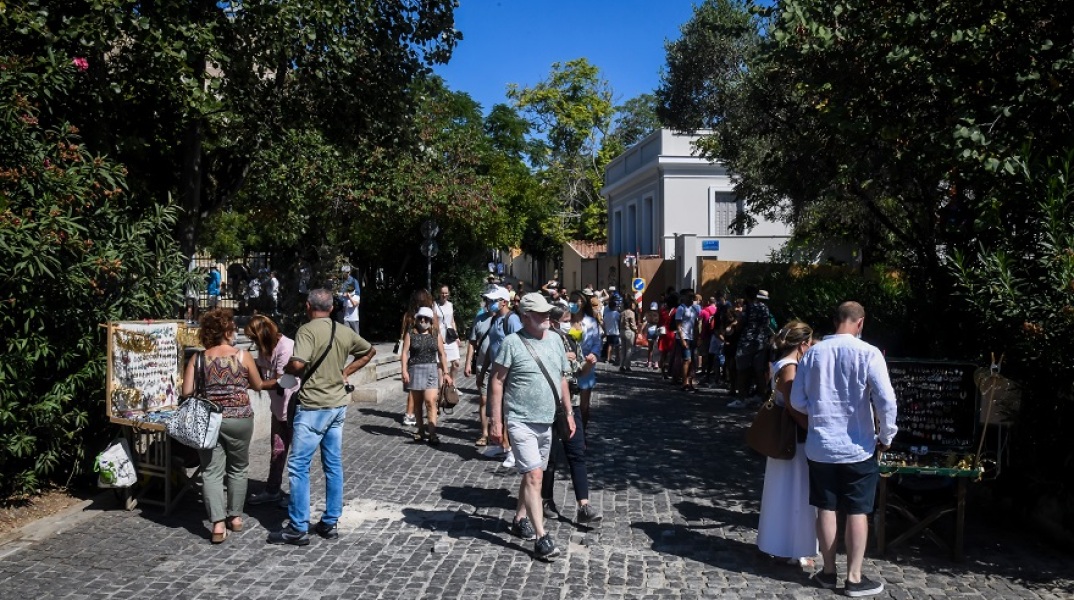 Πολίτες περπατούν σε δρόμο της Αθήνας - Η ανακοίνωση του ΕΟΔΥ για τις περιοχές όπου εντοπίστηκαν τα νέα κρούσματα