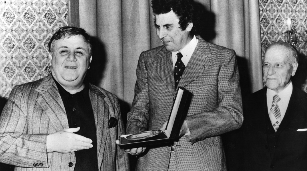 Ο Μίκης Θεοδωράκης δείχνει το βραβείο του στον Μάνο Χατζιδάκι, Ίδρυμα Ωνάση, Φεβρουάριος 1977