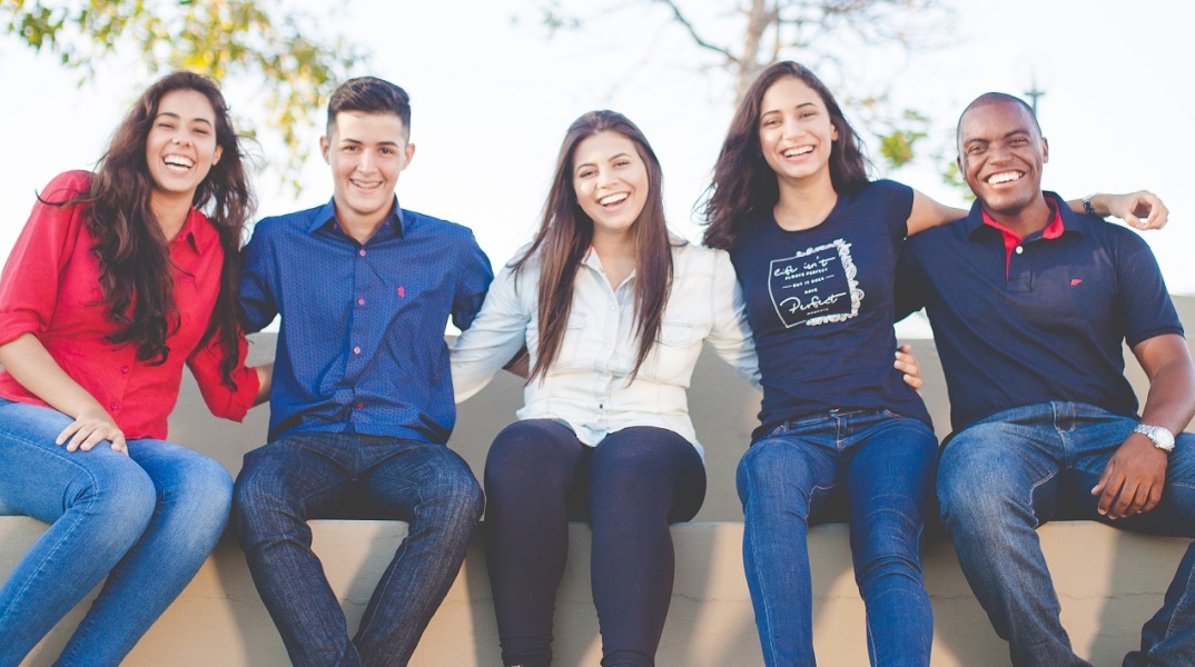 Νέα παιδιά καθισμένα αγκαλιάζονται