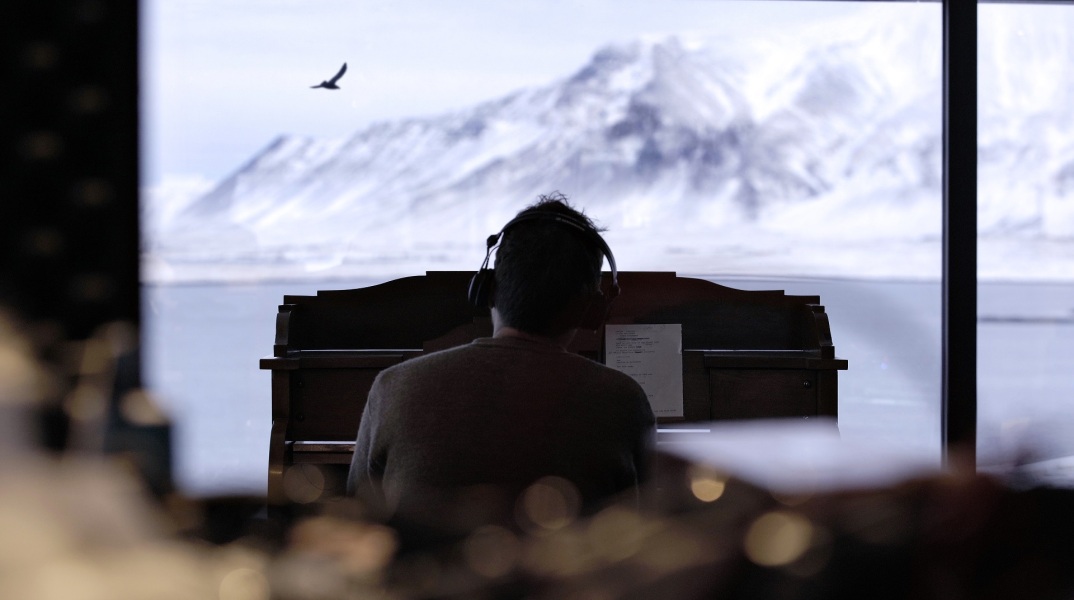 O Damon Albarn παίζει πιάνο κοιτώντας από το παράθυρό του τη θάλασσα