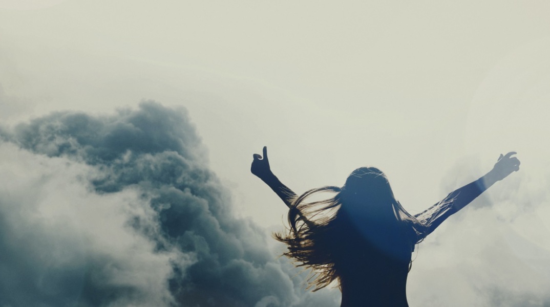 Μια κοπέλα με τα χέρια ανοιχτά.