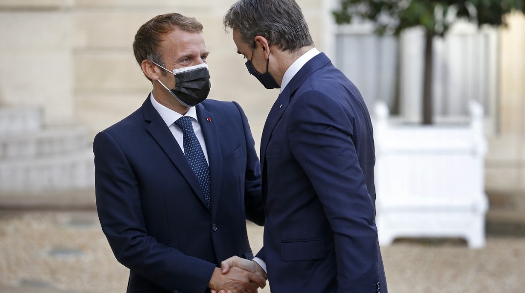 Εμανουέλ Μακρόν και Κυριάκος Μητσοτάκης ανταλλάσσουν χειραψία