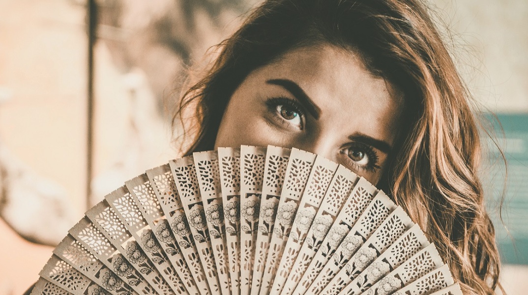 Μια γυναίκα κρατά μια βεντάλια.