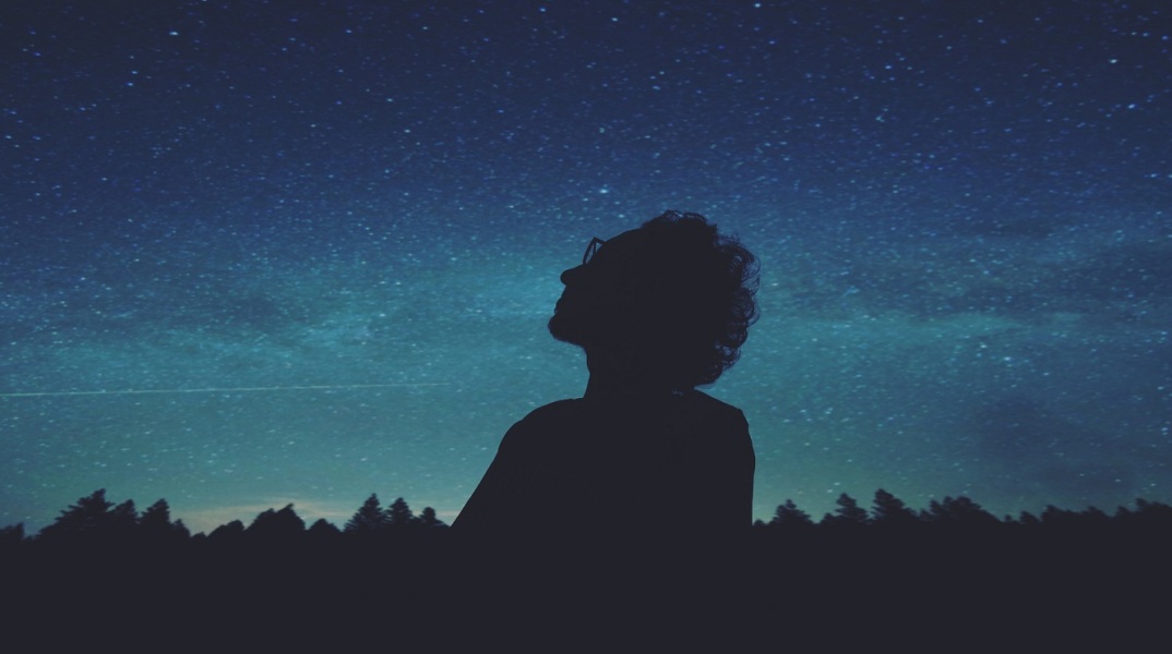 Άνθρωπος που κοιτάζει τον ουρανό με άστρα