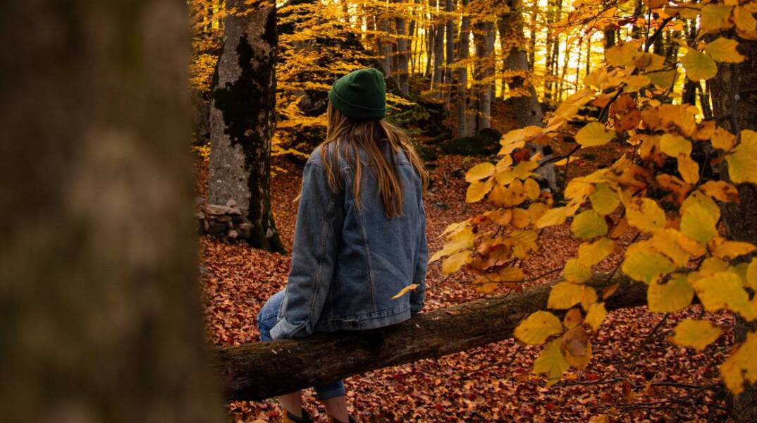 Κοπέλα με denim look και πράσινο σκούφο σε φθινοπωρινό σκηνικό