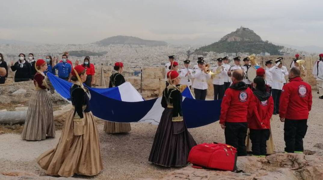 12 Οκτωβρίου 2021: Κοπέλες από το Λύκειο των Ελληνίδων μεταφέρουν τη σημαία της Απελευθέρωσης στον ιερό βράχο της Ακρόπολης