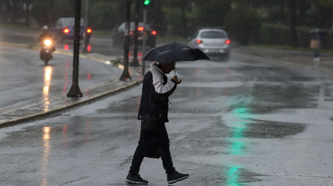 Πολίτης με ομπρέλα στην καταιγίδα - Έντονες βροχές έφερε η κακοκαιρία «Μπάλλος» σε περιοχές στην Αττική
