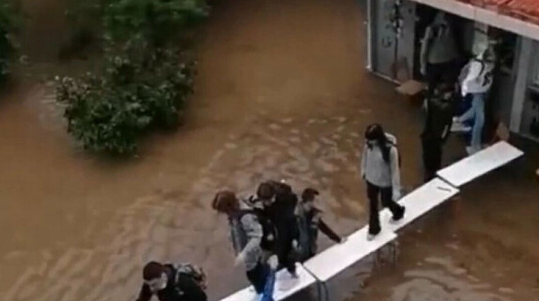 Μαθητές σε πλημμυρισμένο σχολείο στη Νέα Φιλαδέλφεια χρησιμοποιούν μια «γέφυρα» από θρανία