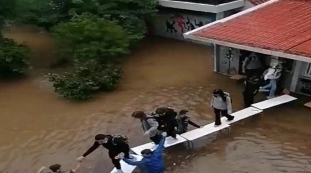 «Γέφυρα» από θρανία έφτιαξαν μαθητές σε πλημμυρισμένο σχολείο 