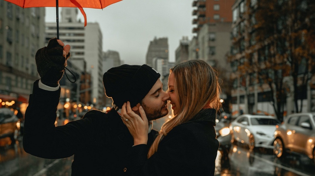 Ένα ζευγάρι φιλιέται στην βροχή. 
