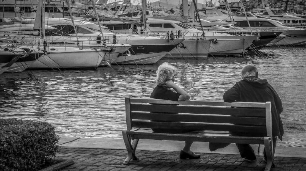 Ηλικιωμένοι κάθονται σε παγκάκι στην Μαρίνα Αλίμου
