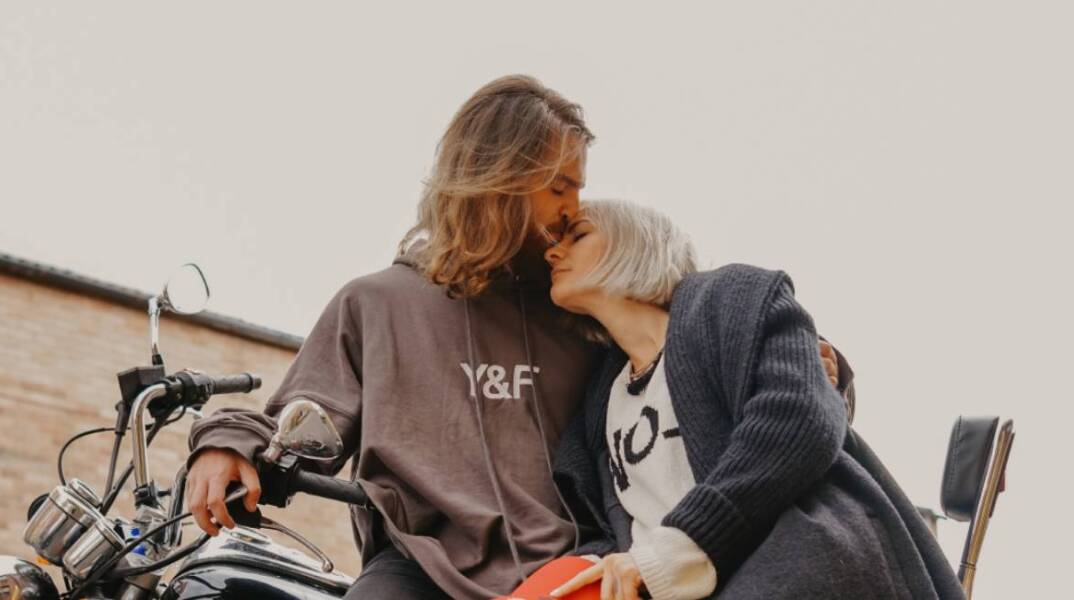 Άντρας φιλάει τη γυναίκα στο μέτωπο ενώ σκέκονται πάνω στη μηχανή