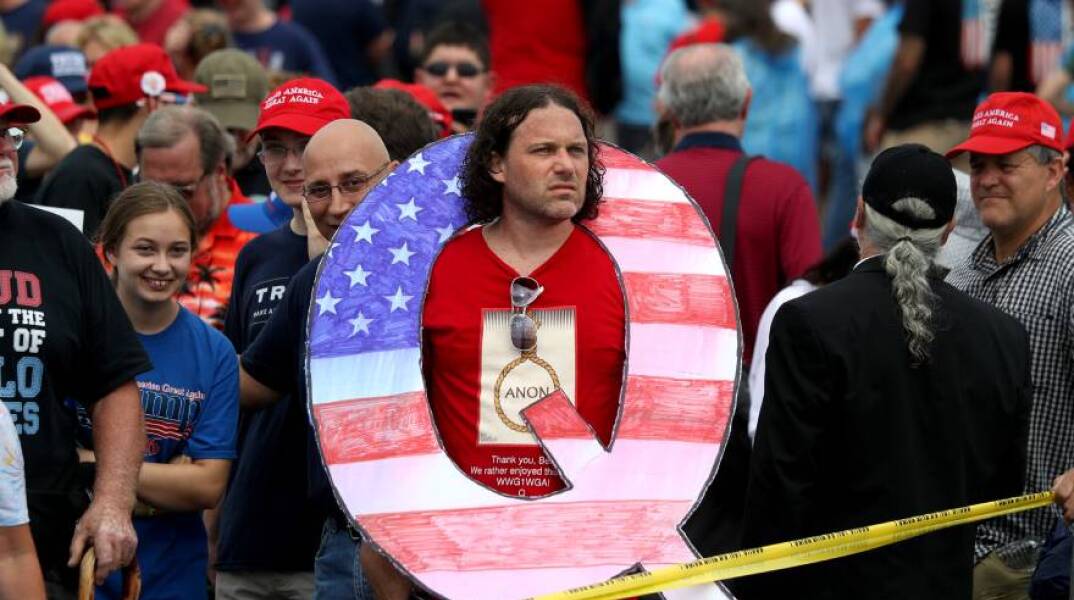 Ο Ντέιβιντ Ράινερτ κρατά ένα μεγάλο πλακάτ "Q" ενώ περιμένει στην ουρά για να δει τον Πρόεδρο Ντόναλντ Τζ. Τραμπ