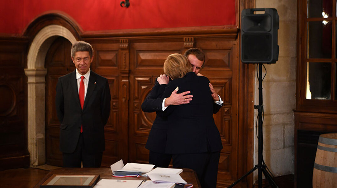 Ο Εμανουέλ Μακρόν αγκαλιάζει την Άνγκελα Μέρκελ στην τελευταία τους συνάντηση στη Γαλλία πριν αποσυρθεί από την πολιτική η καγκελάριος της Γερμανίας
