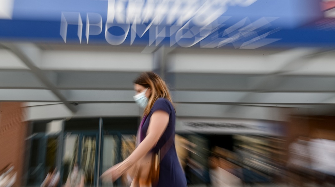 Γυναίκα με μάσκα έξω από το εμβολιαστικό κέντρο Προμηθέας