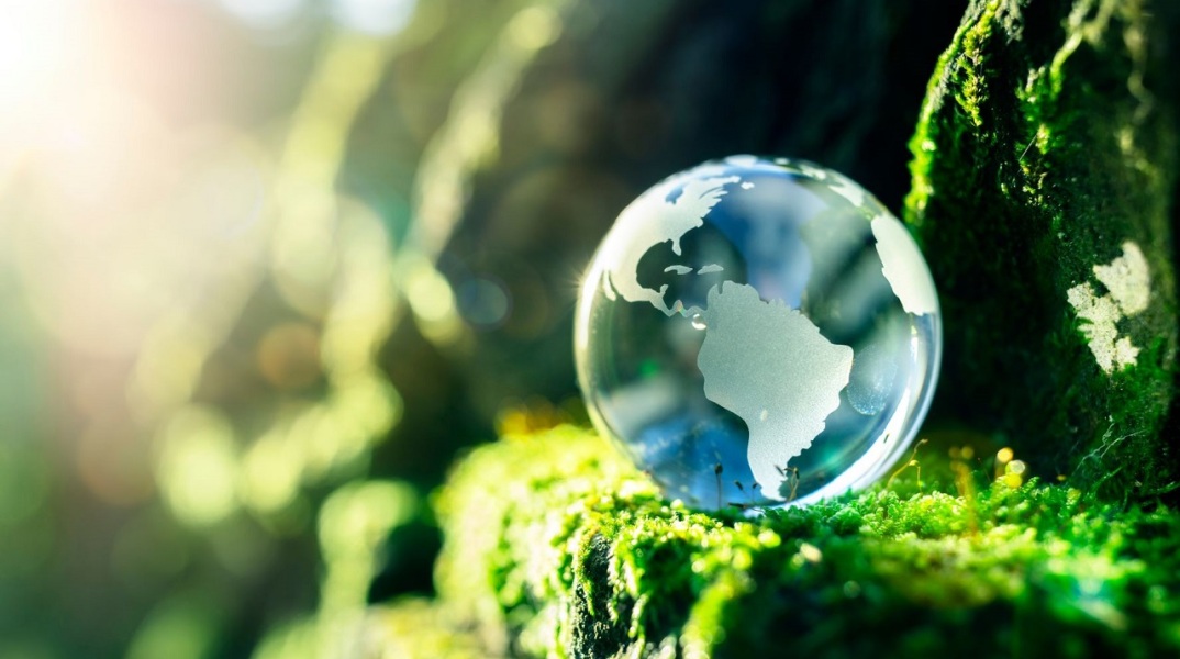 Σταγόνα που μοιάζει με τον πλανήτη γη, ακουμπισμένη σε πόα