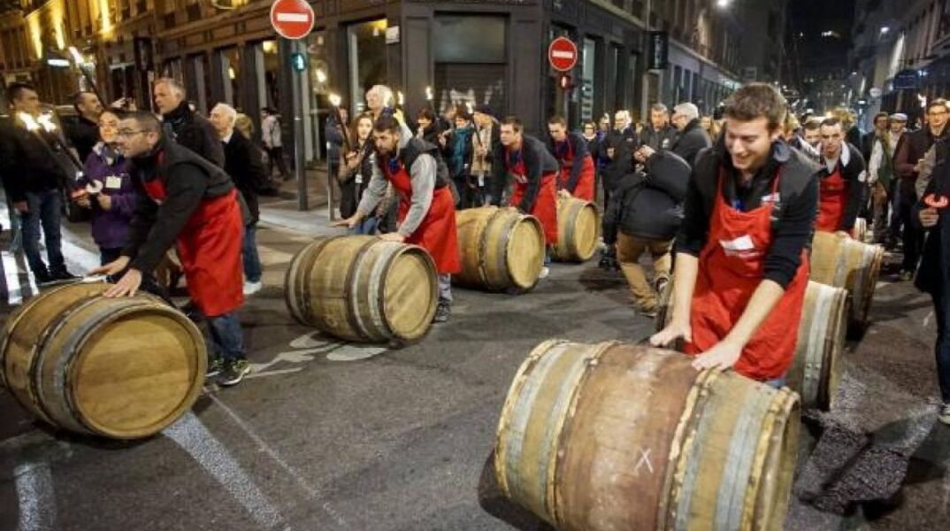 Οινοπαραγωγοί κυλούν τα βαρέλια του στους δρόμους της Λυών γιορτάζοντας τον ερχομό των Beaujolais Nouveau