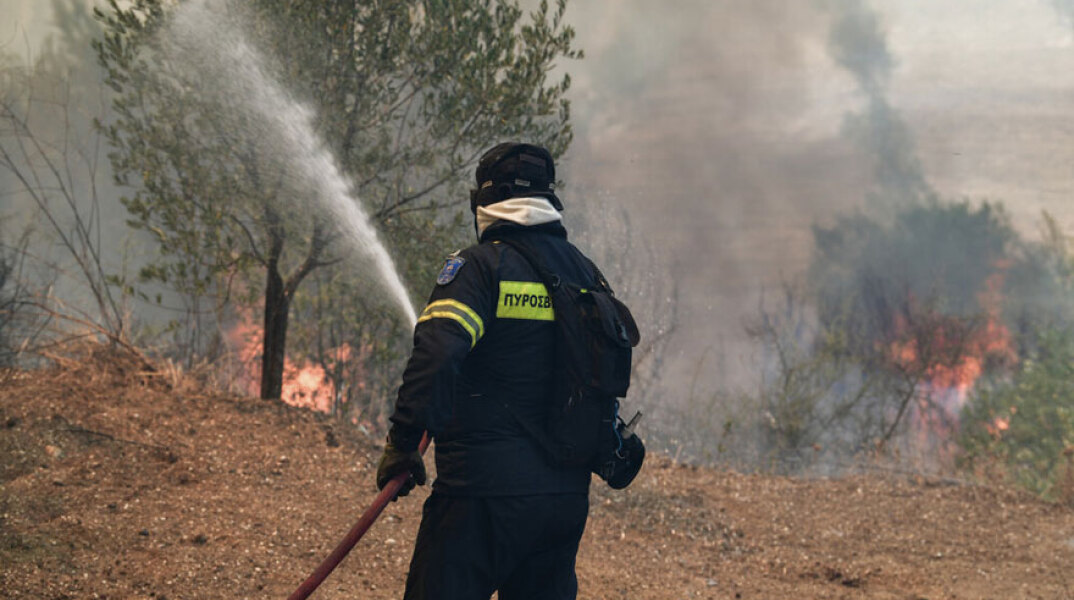 Πυροσβέστης ρίχνει νερό σε φωτιά (ΦΩΤΟ ΑΡΧΕΙΟΥ) - Λαχτάρησαν οι κάτοικοι με την πυρκαγιά στην Τήνο
