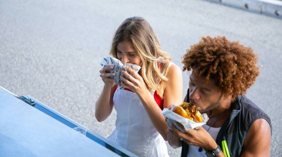 Ζευγάρι τρώει junk food από καντίνα στον δρόμο