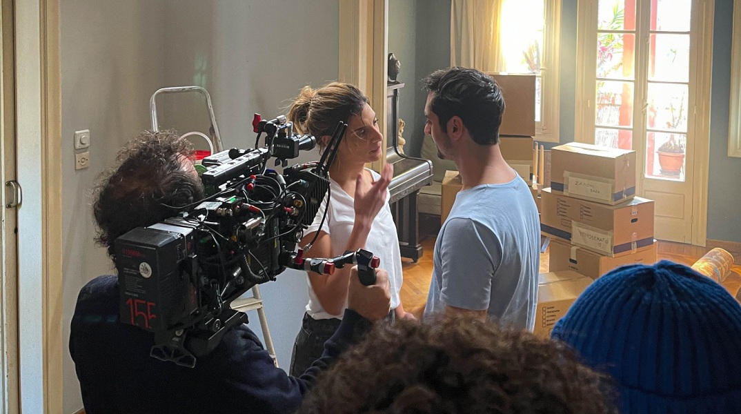 Άνδρας και γυναίκα περιστοιχισμένοι από κινηματογραφικό συνεργείο