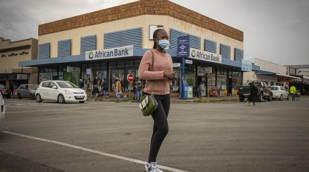 Γυναίκα με μάσκα περπατά σε δρόμο, στη Νότιο Αφρική
