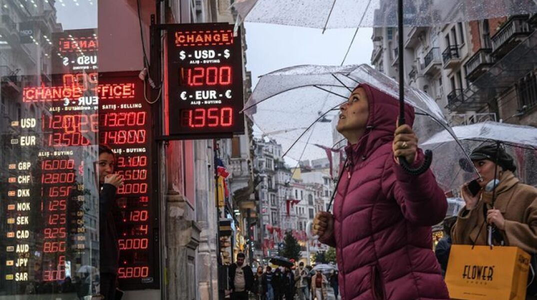 Η τουρκική λίρα σε ελεύθερη πτώση με πολίτες να παρακολουθούν την ισοτιμία με δολάριο και ευρώ έξω από ανταλλακτήριο συναλλάγματος στην Κωνσταντινούπολη © EPA/SEDAT SUNA  