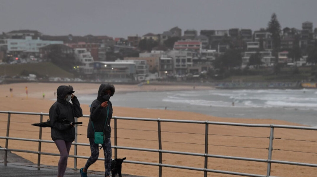 Κοπέλες με μάσκα για τον κορωνοϊό στο Σίδνεϊ - Κρούσματα από τη μετάλλαξη Όμικρον εντοπίστηκαν στην Αυστραλία