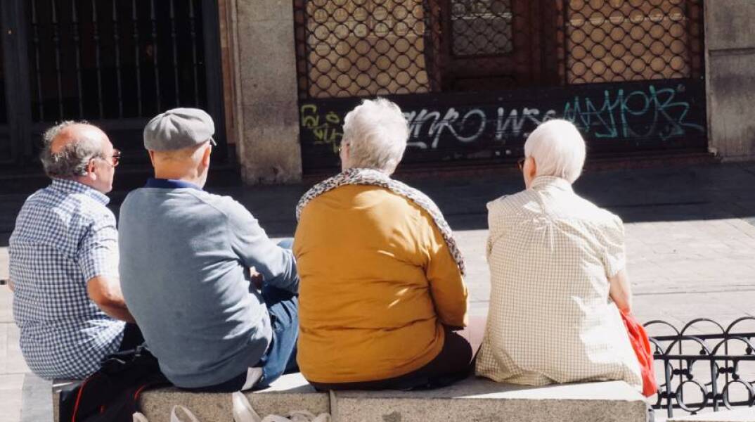 Ηλικιωμένοι κάθονται σε παγκάκι και συζητούν
