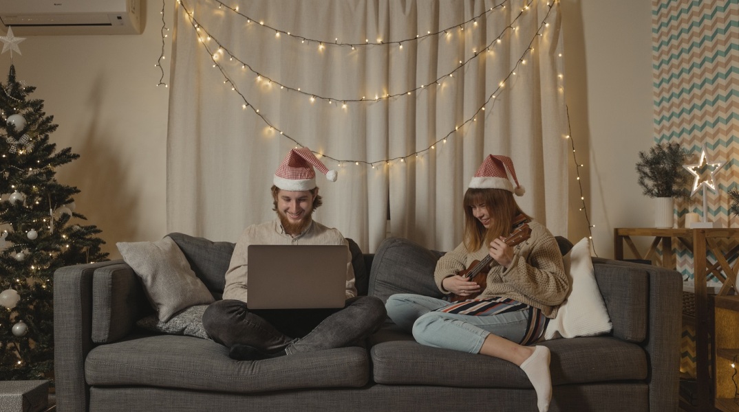 Άνδρας που κοιτά το λάπτοπ του και γυναίκα που παίζει γιουκαλίλι