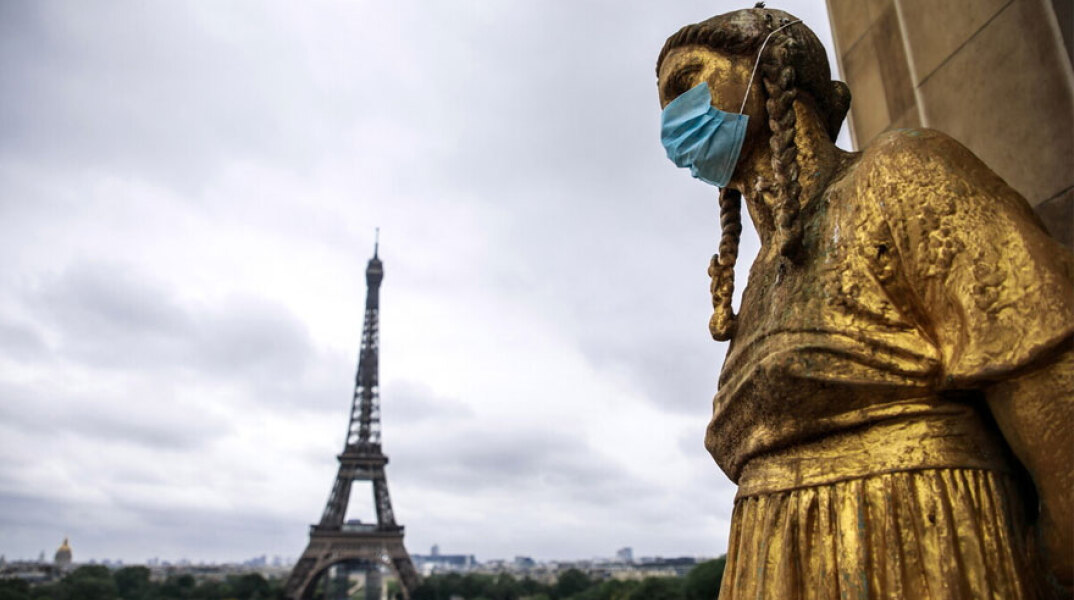 Άγαλμα με μάσκα για τον κορωνοϊό με φόντο τον Πύργο του Άιφελ στο Παρίσι