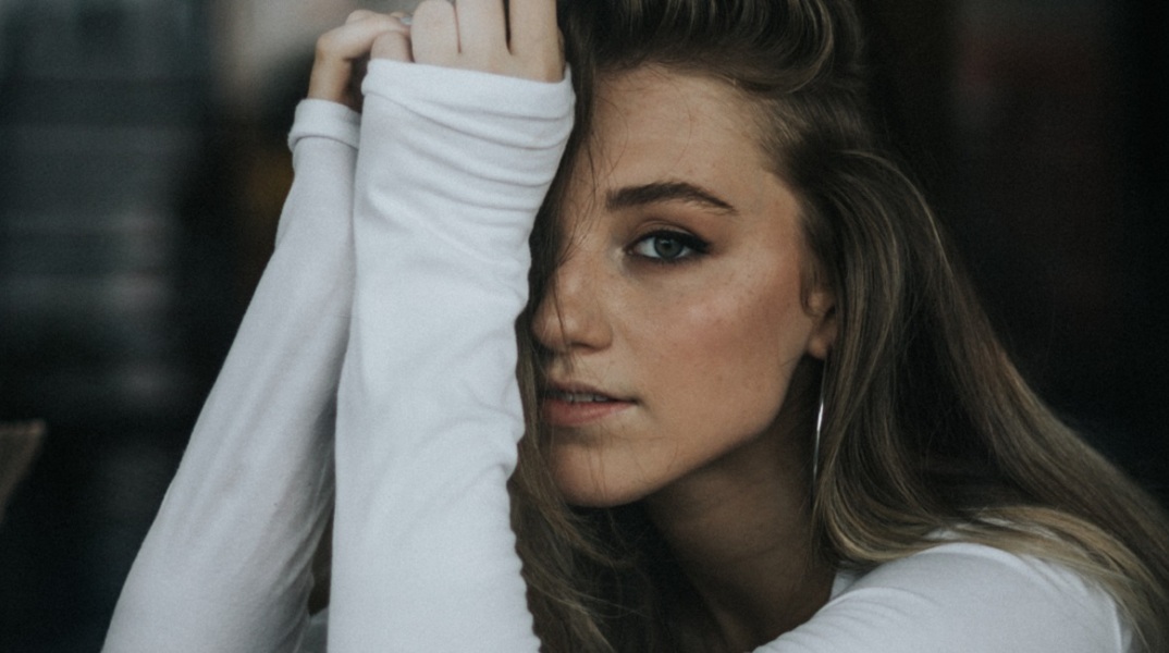 Ένα κορίτσι ποζάρει και κοιτάει την κάμερα