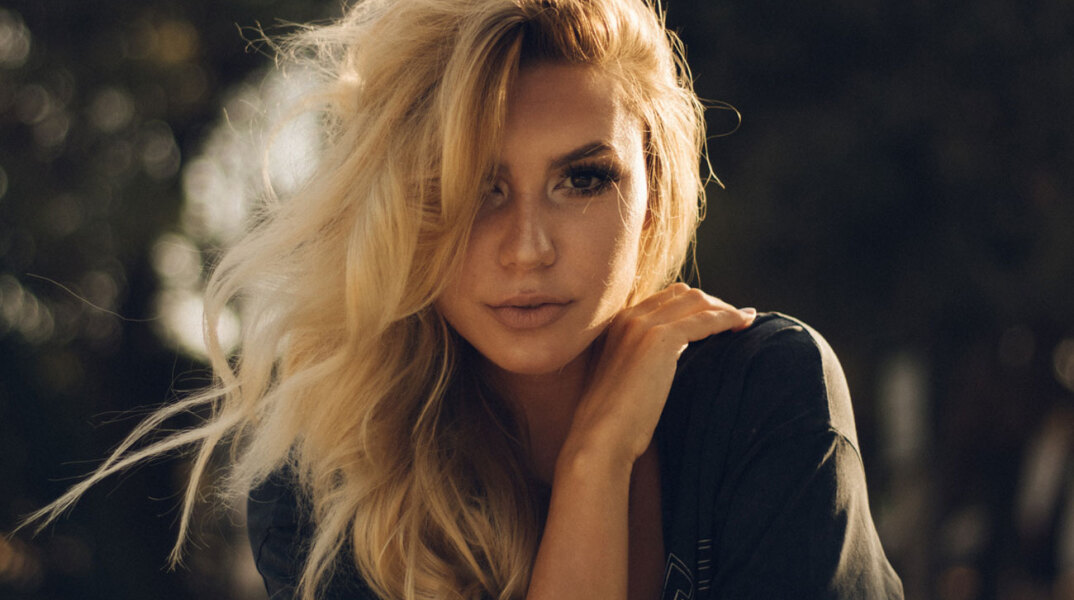 Ξανθιά γυναίκα στέκεται όρθια