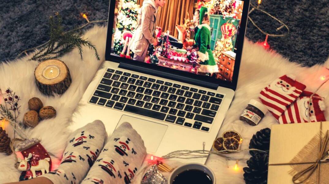 Μια κοπέλα βλέπει χριστουγεννιάτικη ταινία στο λάπτοπ