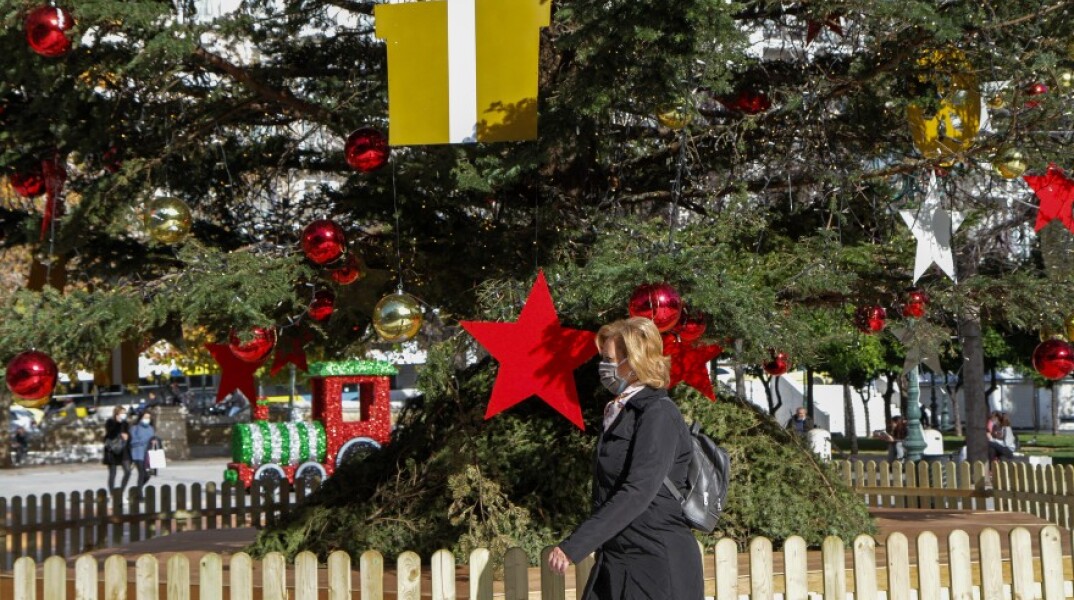 Πολίτης με μάσκα στο στολισμένο Σύνταγμα