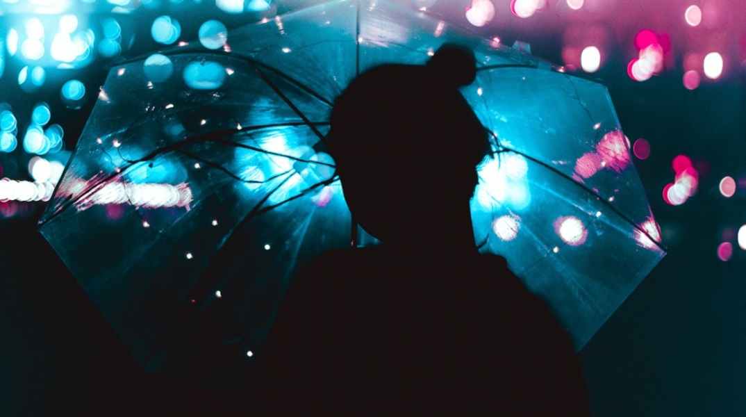 Μια καλλιτεχνική φωτογραφία ενός κοριτσιού που κρατάει μια ομπρέλα. 