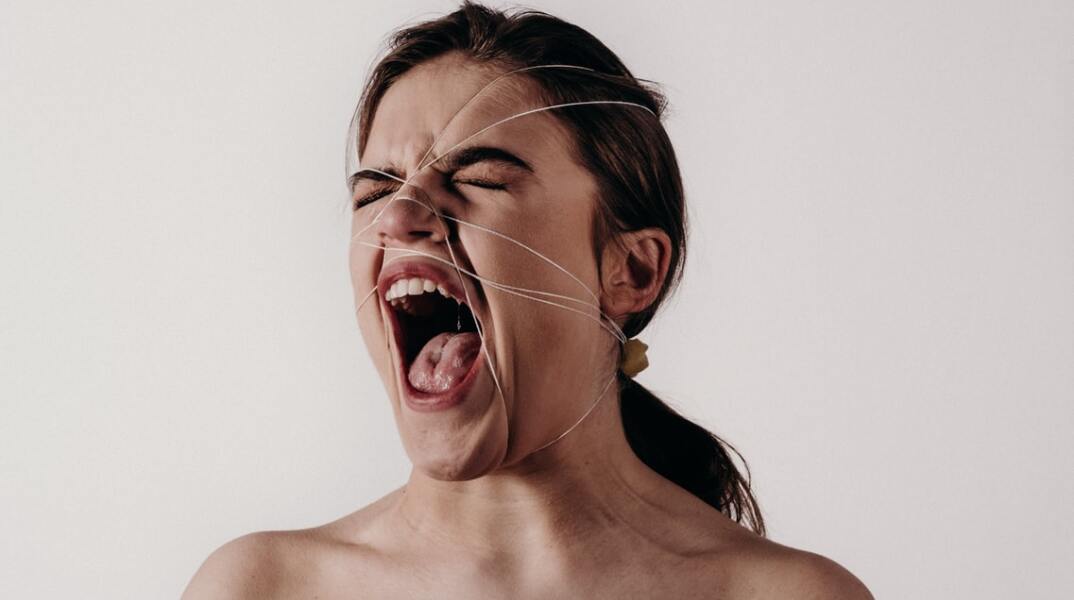 Γυναίκα που ουρλιάζει φορώντας δίχτυ στο πρόσωπό της