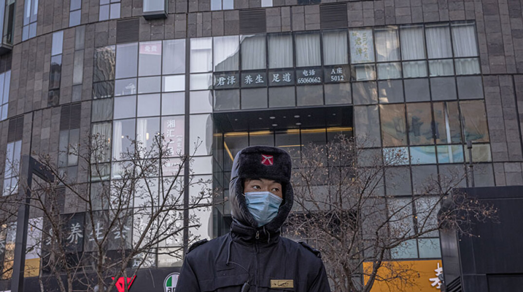 Αστυνομικός με μάσκα για τον κορωνοϊό στο Πεκίνο - Η Κίνα έφθασε τις 100.000 κρούσματα