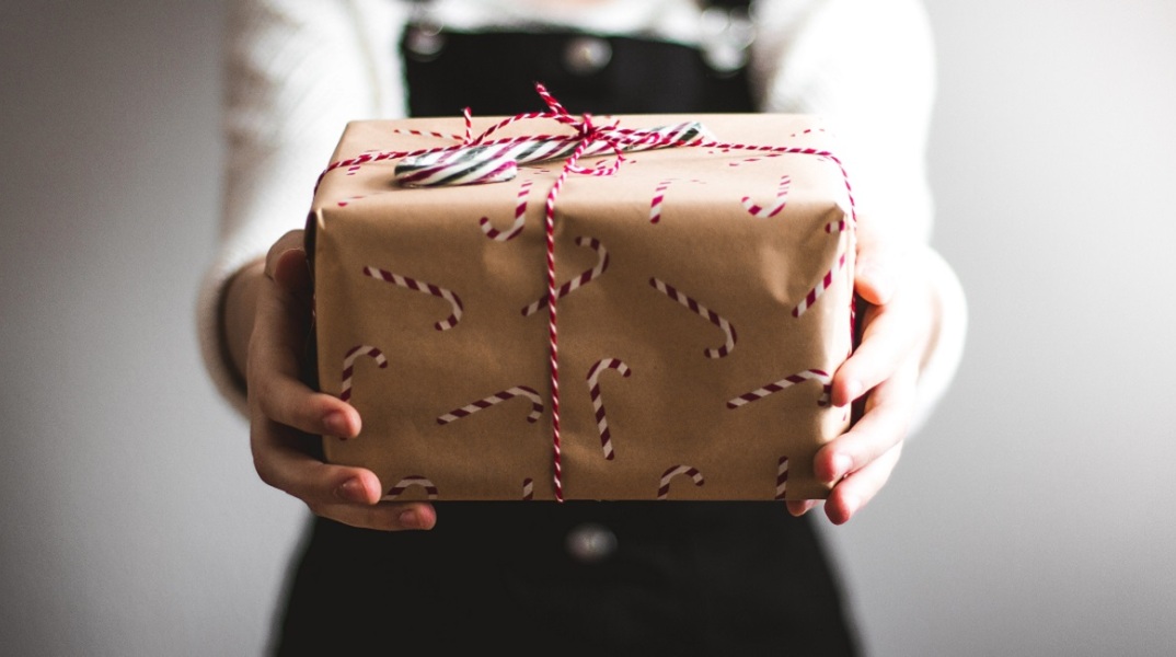 Μια κοπέλα κρατάει ένα δώρο.