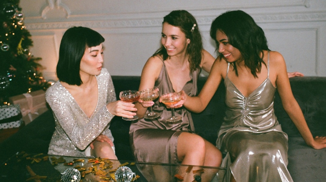 Τρια κορίτσια πίνουν κρασί κάτω από το δέντρο