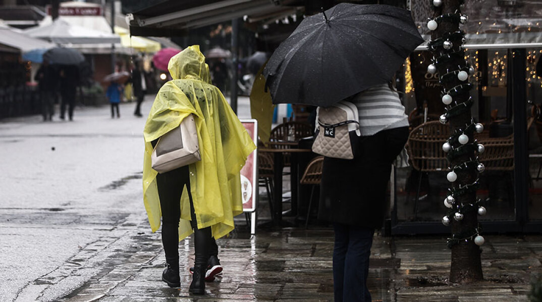 Πολίτες με ομπρέλα στη βροχή