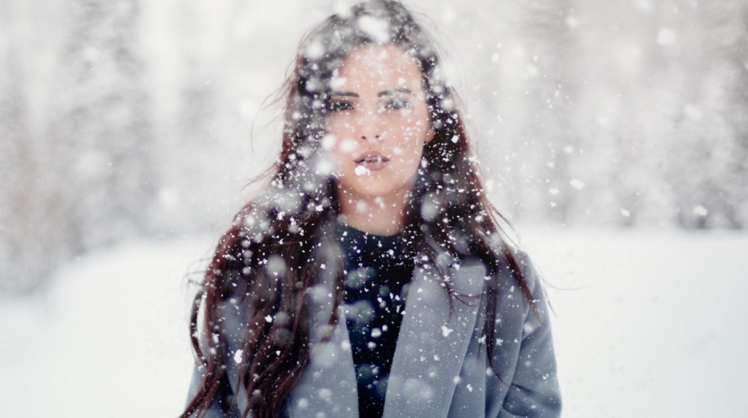 Ένα κορίτσι ποζάρει στα χιόνια.