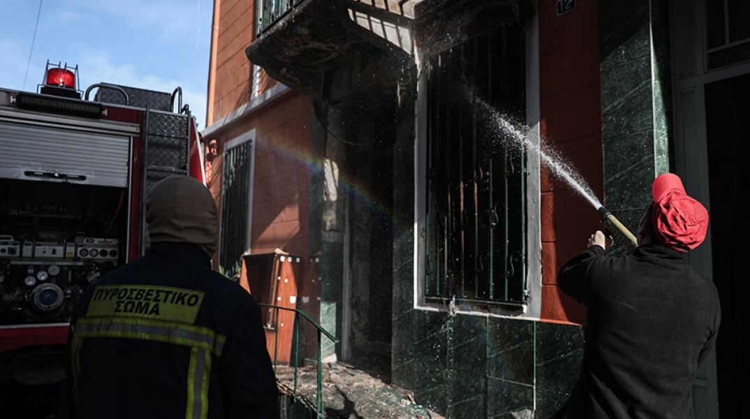 Πυροσβέστης ρίχνει νερό στο σπίτι που πήρε φωτιά στο Μεταξουργείο