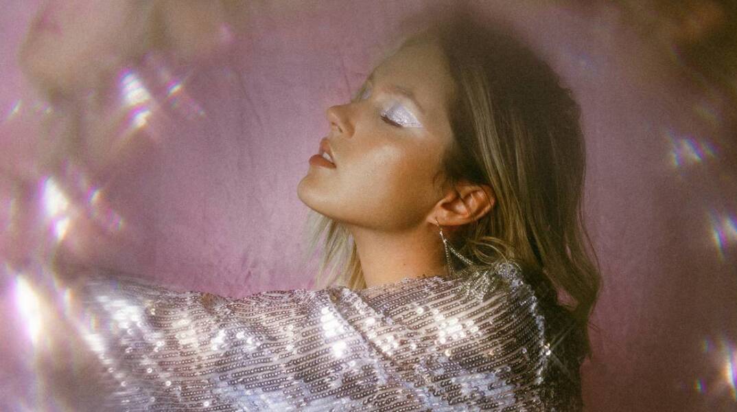 Ξανθιά κοπέλα με λαμέ μπλούζα