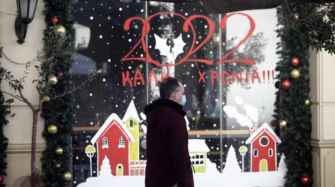 Άνδρας έξω από στολισμένη βιτρίνα μαγαζιού - Στιγμιότυπο από τη Θεσσαλονίκη την περίοδο των Χριστουγέννων 