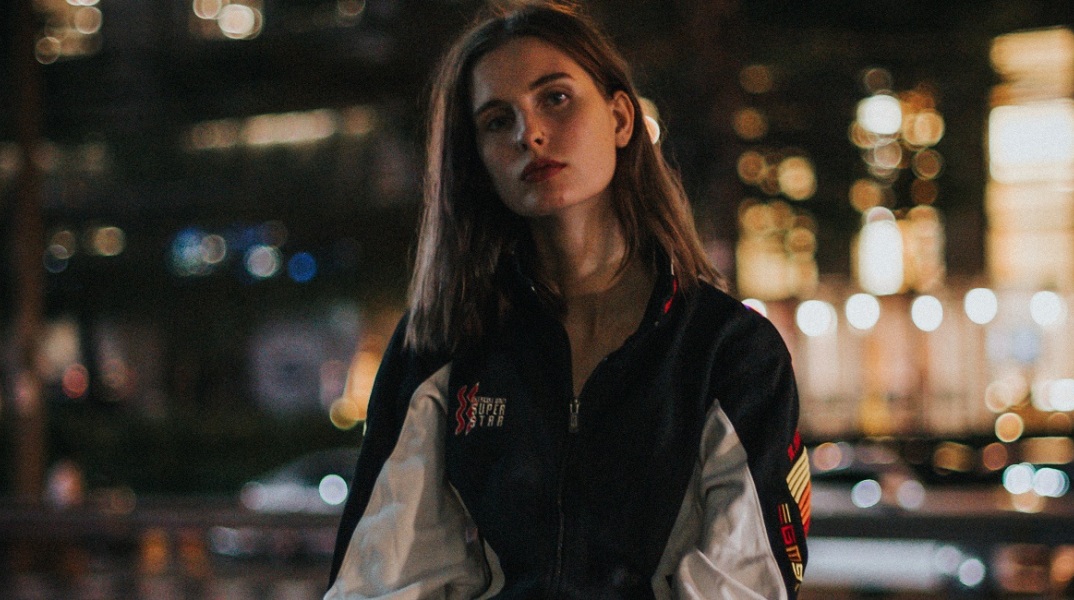 Ένα κορίτσι ποζάρει κοιτώντας την κάμερα.