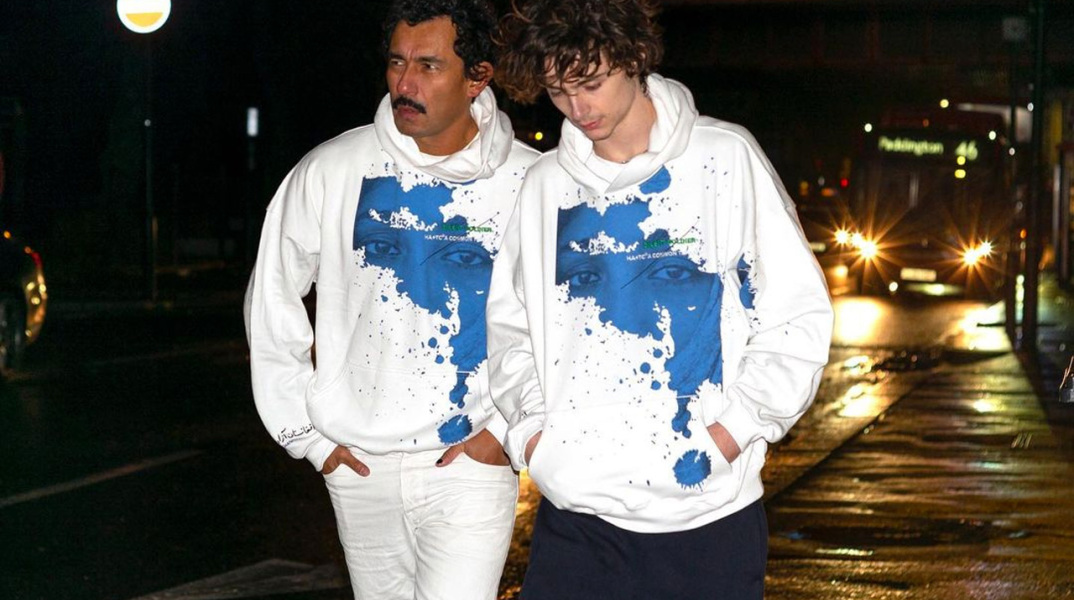 Ο σχεδιαστής Χάιντερ Άκερμαν και ο Τιμοτέ Σαλαμέ φορούν το hoodie που σχεδίασαν μαζί